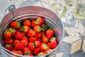 Romantic still life with bucket with fresh strawberries and glases of white wine, selective focus