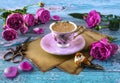 Romantic still life with pink cup of coffee, pink peony roses, vintage paper, scissors, decorative bird Royalty Free Stock Photo