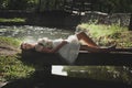 Romantic style young woman lie on small wooden bridge over pond Royalty Free Stock Photo