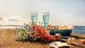 romantic summer sunset on sea Wonderful Wild flowers two blue er in the clean Baltic Sea seashell on the rock Blue glass cup an