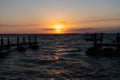 romantic sundown seascape with silhouette pier jet ski and yacht boats, summer vacation.