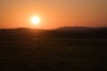 romantic sunset behind a hill in front of a meadow Royalty Free Stock Photo