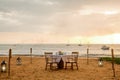 Romantic sunset dinner on beach. Table honeymoon set for two with luxurious food, glasses of champagne drinks in Royalty Free Stock Photo