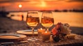 Romantic sunset dinner on the beach. Table honeymoon set for two with luxurious food, glasses of rose wine drinks in a restaurant Royalty Free Stock Photo