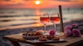 Romantic sunset dinner on the beach. Table honeymoon set for two with luxurious food, glasses of rose wine drinks in a restaurant Royalty Free Stock Photo