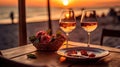 Romantic sunset dinner on the beach. Table honeymoon set for two with luxurious food, glasses of rose wine drinks in a restaurant Royalty Free Stock Photo