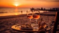 Romantic sunset dinner on the beach. Table honeymoon set for two with luxurious food, glasses of rose wine drinks in a restaurant Royalty Free Stock Photo