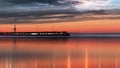 Pink sunset  on pier at sea on horizin promenade with blurred night light cloudy dramatic  blue sky  on starry sk Royalty Free Stock Photo