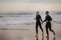 Romantic Surfers Couple Running Together Along The Beach Royalty Free Stock Photo