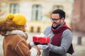 Romantic surprise for Christmas. Couple with present outdoor Royalty Free Stock Photo