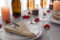 Romantic table setting with burning candles and rose petals Royalty Free Stock Photo