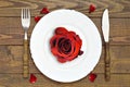 Romantic table setting. Red rose on empty plate Royalty Free Stock Photo