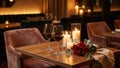 Romantic table setting for two with red wine and roses. Intimate candlelight dinner in an elegant restaurant for an anniversary or Royalty Free Stock Photo