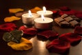 3 Romantic Tealights With Chocolate and Rose Petals Royalty Free Stock Photo