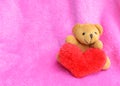 Romantic teddy bear and red heart on pink backgrounds