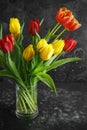 Romantic tulips bouqet on rustic dark background