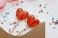 Romantic Valentine`s day background. Valentine`s day gift. Postcard and two lollipops in the shape of red hearts. Royalty Free Stock Photo