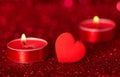 Romantic Valentine`s Day. Lit scented candles and red heart on bright sparkling background with bokeh effect Royalty Free Stock Photo