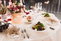 Romantic table setting with wine, beautiful flowers in box, empty glasses, rose petals and candles Royalty Free Stock Photo