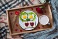 Romantic valentines day breakfast in bed with heart-shaped eggs, toasts, jam, coffee, rose and petals Royalty Free Stock Photo