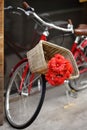 Romantic view of bike with bouquet of red flowers on street of town Royalty Free Stock Photo