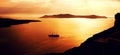 Romantic views of Santorini at sunset with tour boat sailing in the distance