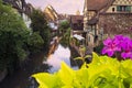 Romantic village with half-timbered houses by the bank of canal, sunset sky, flowers on the bridge. Summertime in Colmar , Alsace Royalty Free Stock Photo