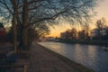 Romantic walk way beside the river, full of benches, boats and a bridge at the end Royalty Free Stock Photo