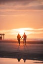Romantic walk of a young couple on the beaches of Oostende in western Belgium at sunset. Love and devotion. Reflection in a pool Royalty Free Stock Photo