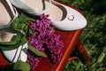 Romantic wedding arrangement of a pair of bride's shoes on a stool and wedding rings