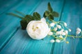 Romantic white bouquet with rose tree and lilly of the valley flowers, teal wooden background. Royalty Free Stock Photo
