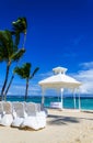 Romantic white gazebo in the exotic Caribbean gardens with palm trees.