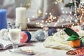 Romantic winter and New Year`s style interior view with a candle, book, garland and glass of milk