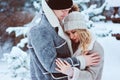 romantic winter portrait of couple embracing outdoor on the walk in snowy forest.
