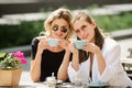 Romantic woman friends with coffee cup in cafe. Spending good time with best friend. Two beautiful women in sunglasses Royalty Free Stock Photo