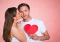 Romantic woman kissing on the cheek of man holding a heart shape Royalty Free Stock Photo