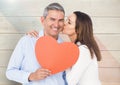 Romantic woman kissing on the cheek of man holding heart shape Royalty Free Stock Photo