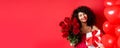 Romantic woman receive bouquet of flowers and gift on holiday, standing near heart balloons and red background, smiling Royalty Free Stock Photo