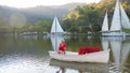 Romantic woman in red dress sailing in the sea or lake on sunset. Attractive happy girl enjoying evening onboard white Royalty Free Stock Photo