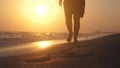 Romantic woman walking on sea shore barefoot at sunset in slow motion with lens flare effects. 1920x1080