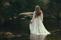 Romantic woman walks into a stream