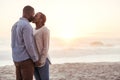 Romantic young African couple kissing on a beach at sunset Royalty Free Stock Photo