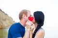 Romantic young caucasian couple kissing on the seaside hiding be Royalty Free Stock Photo