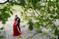 Romantic young couple embracing under a tree.