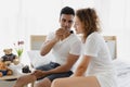 Romantic young couple enjoying cake together on the bed in bedroom Royalty Free Stock Photo