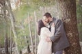 Romantic young couple kissing under a tree on a cold fall day