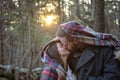 Romantic young couple kissing under a blanket in the New England woods Royalty Free Stock Photo