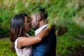 Romantic young couple kissing underneath branches in an outdoor park Royalty Free Stock Photo