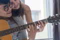 Romantic Couple playing guitar together happily in the room.close up Royalty Free Stock Photo