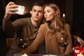 romantic young couple posing for selfie while having dinner at night at restaurant or home, St. Valentine& x27;s Day Royalty Free Stock Photo